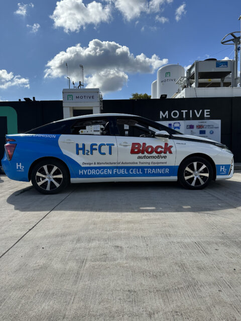 A blue and white car parked in front of a building.