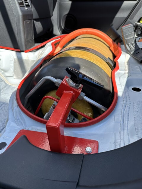 A fire extinguisher in the trunk of a car.