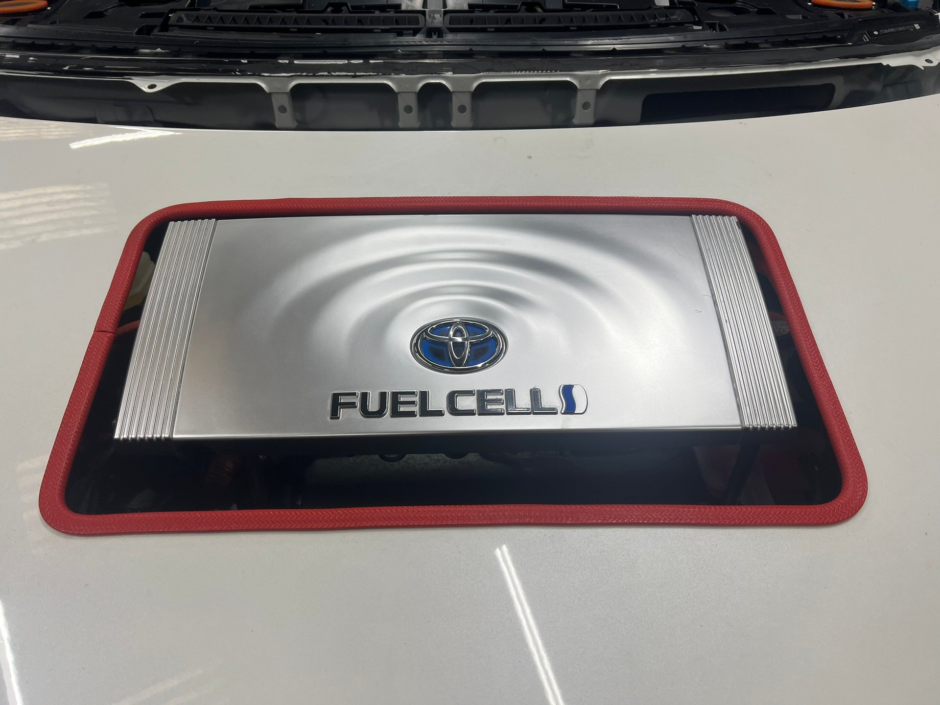 A white car with the word fuel cell on the bonnet.